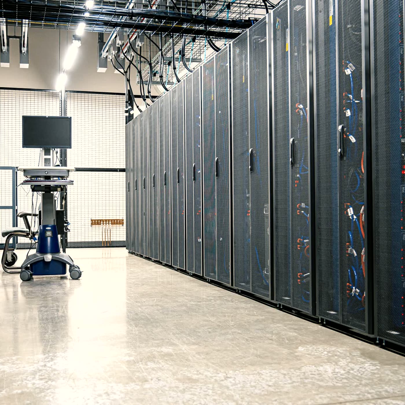 A brightly lit data centre aisle with receding server cabinets