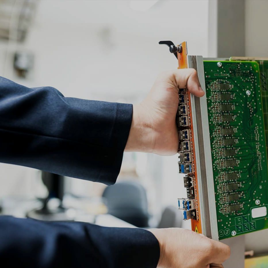 Hands seating a line card into a server chassis